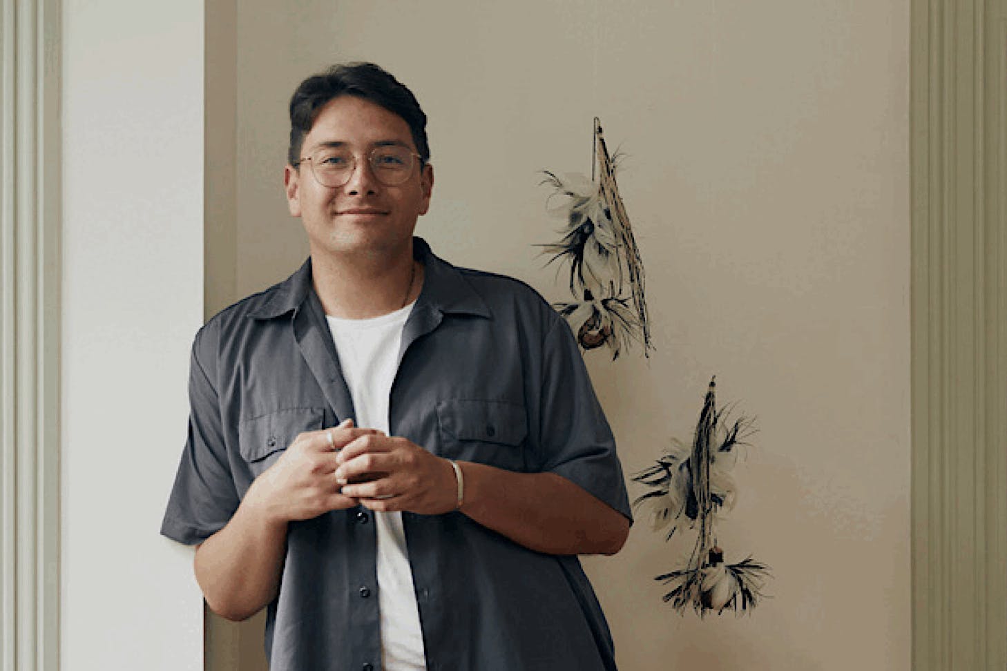 Hāmiora Bailey leans against a wall with a content expression.